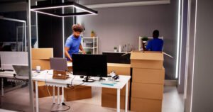 Movers packing boxes in a modern office.