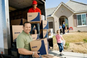 Family and movers unloading boxes at a new house.