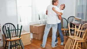Couple dancing in new apartment with moving boxes
