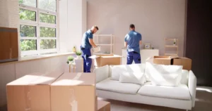 Movers unpacking boxes in a bright living room.