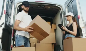 Movers loading cardboard boxes into a delivery van
