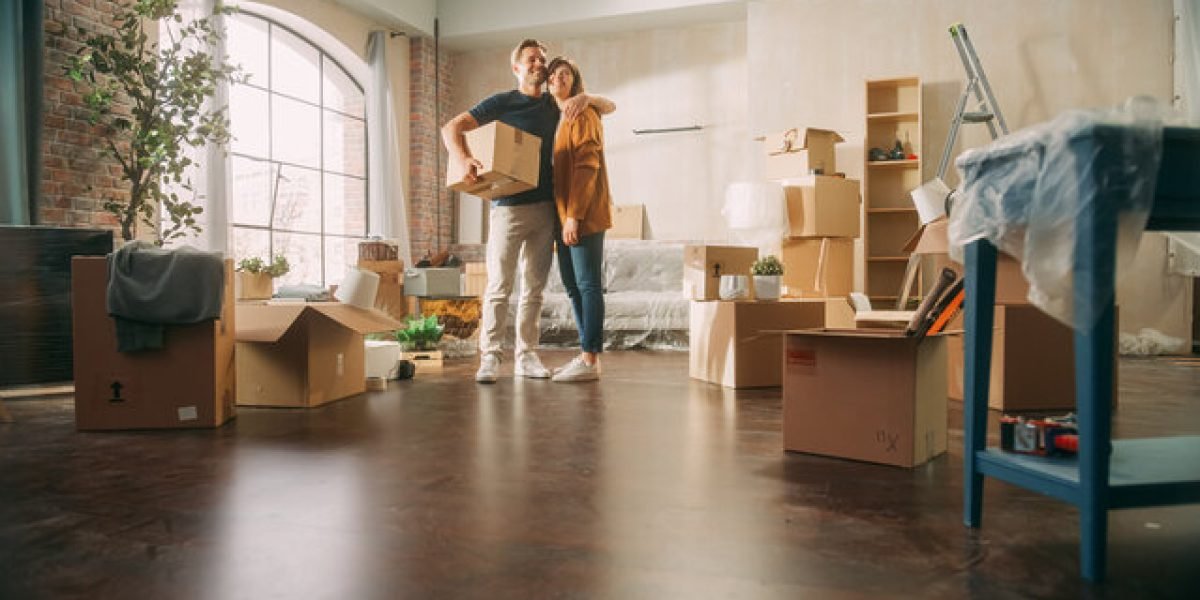 Couple standing in new apartment with moving boxes